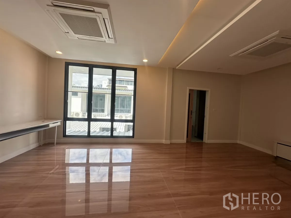 Townhouse for rent in Watthana, Bangkok - Master bedroom with floor-to-ceiling windows, structural column, and dual wardrobes.