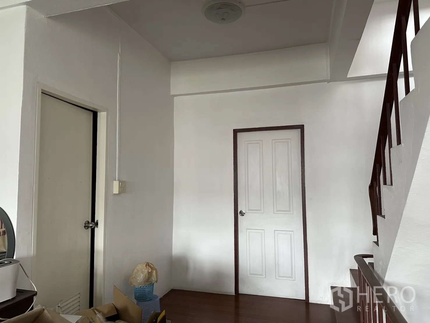 Shophouse for rent in Phra Khanong, Bangkok - Upper-floor landing with two white doors and stair rail.