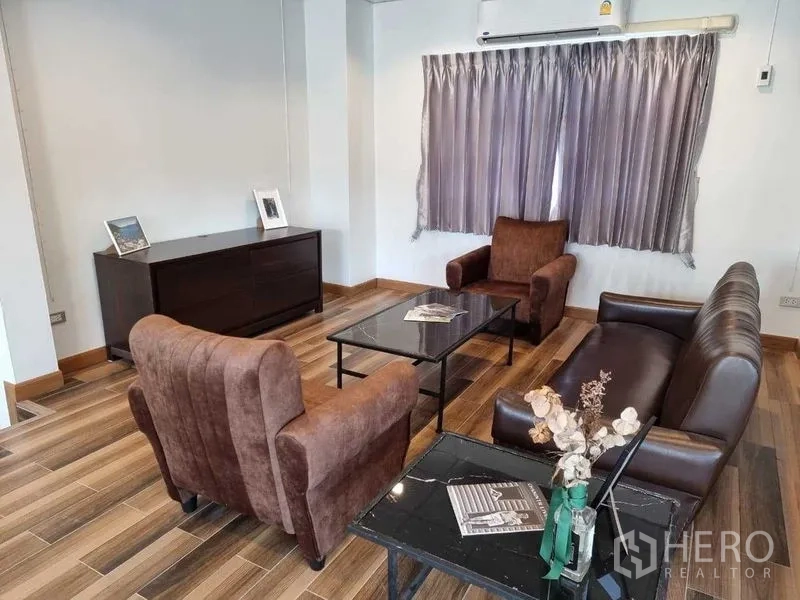 บ้าน ให้เช่าในMueang Nonthaburi, Nonthaburi - มุมนั่งเล่นอบอุ่น โซฟาสีน้ำตาล โต๊ะกลางท็อปหิน และตู้ลิ้นชัก