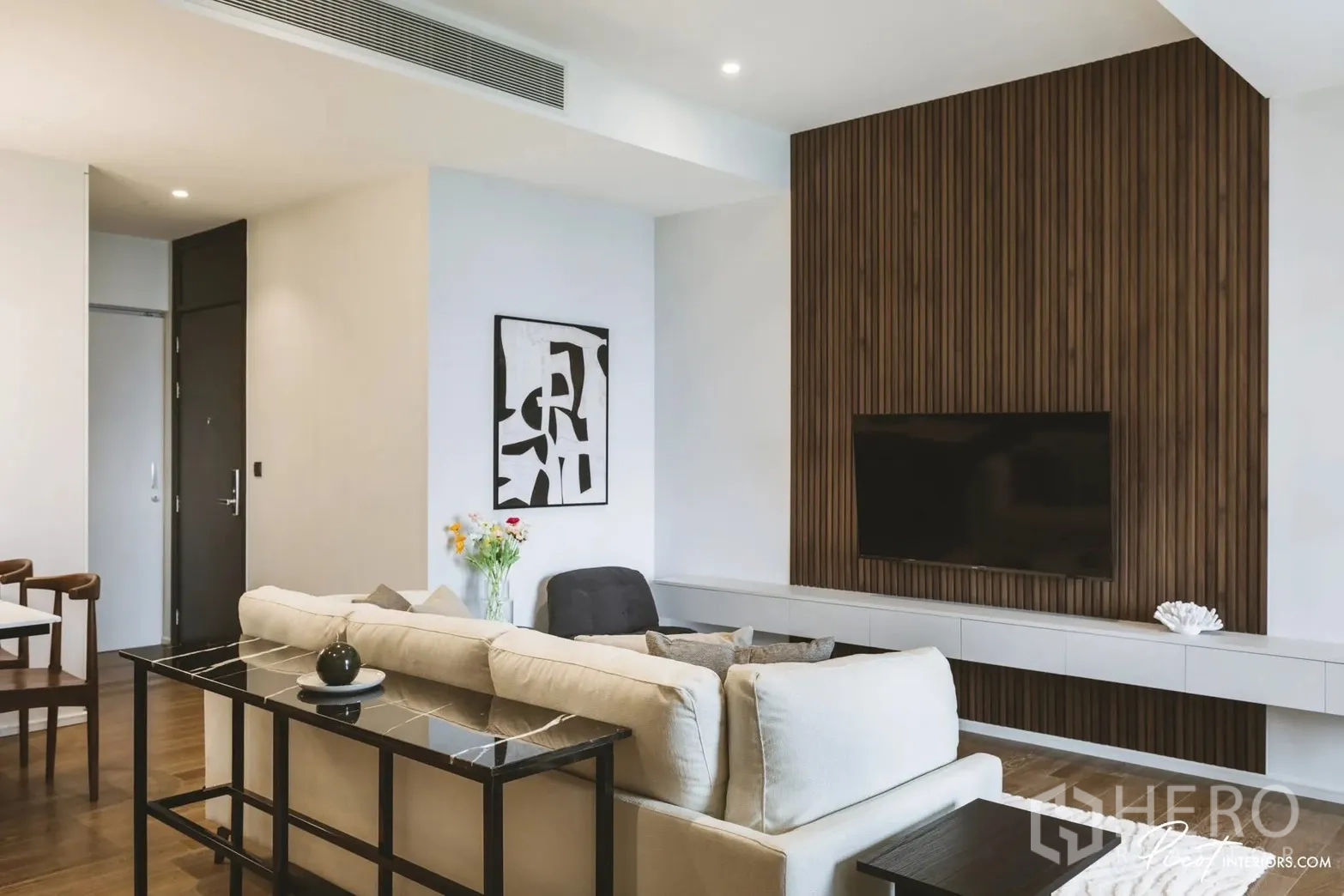 คอนโด for rent in Pathum Wan, Bangkok - ห้องนั่งเล่นผนังตกแต่งลายซี่ไม้ติดทีวีและโซฟาสีเอิร์ธโทน