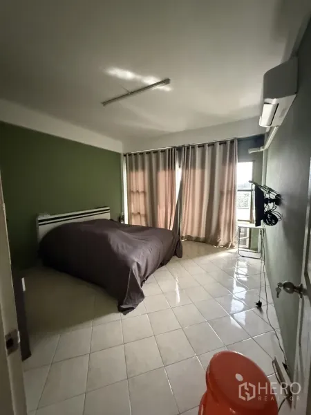 Shophouse for rent in Pak Kret, Nonthaburi - Another view of the bedroom showing window, TV, and sliding door.