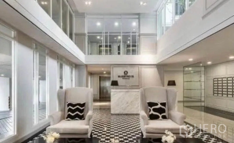 Condominium for rent in Sathon, Bangkok - Elegant double-height lobby with lounge seating and marble reception.