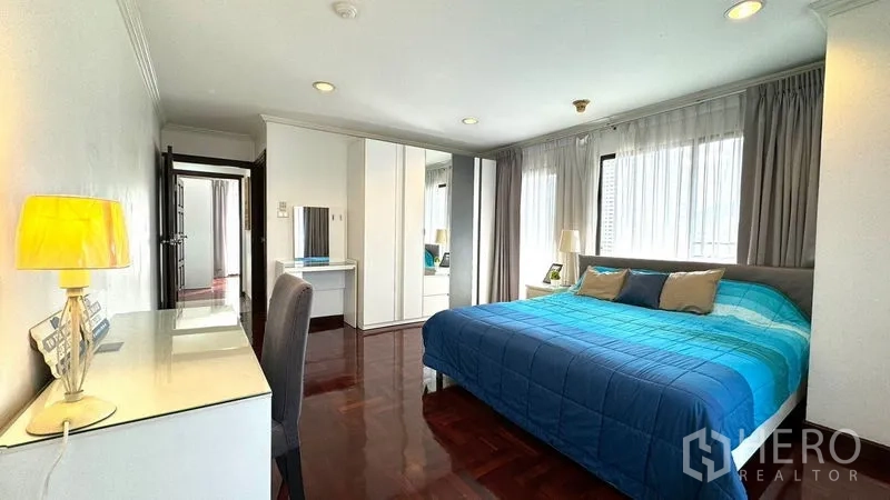 Condominium for rent or sale in Watthana, Bangkok - Spacious bedroom with king bed, desk, and wardrobes.