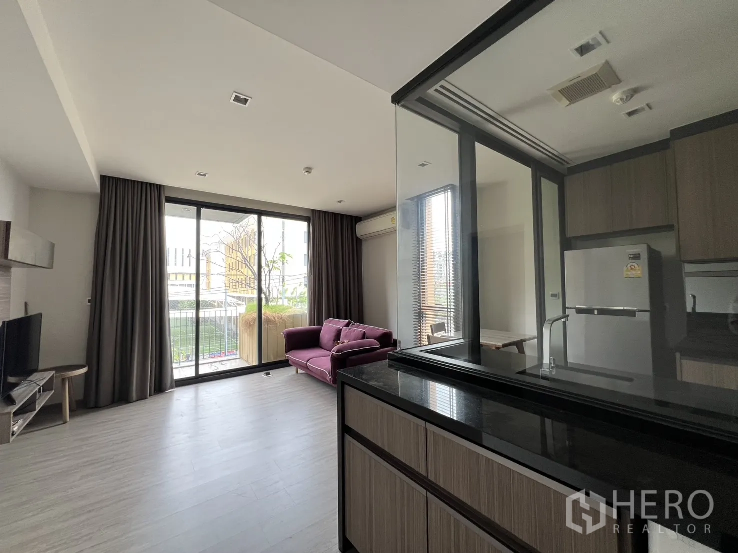 คอนโด for rent in Watthana, Bangkok - มุมมองจากครัวสู่พื้นที่เปิดโล่งและกระบะต้นไม้ริมระเบียง