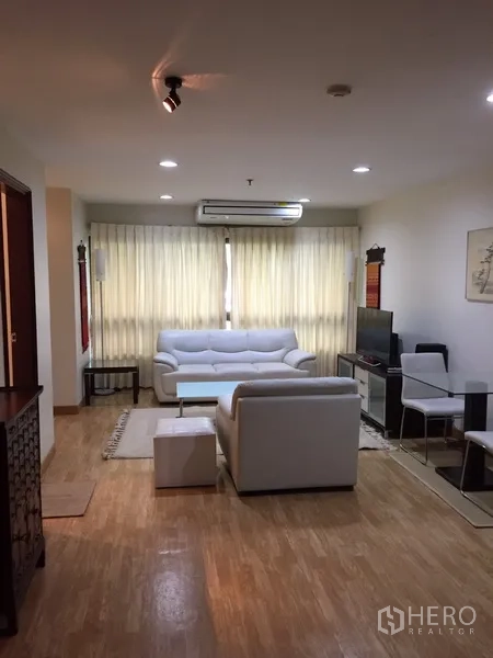 公寓 出租在Pathum Wan, Bangkok - 明亮客厅，白色沙发与窗帘，木地板，电视柜与用餐角。