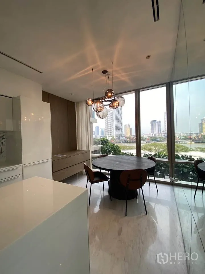 คอนโด for rent in Sathon, Bangkok - มุมรับประทานอาหารสว่างด้วยโต๊ะกลมและโคมไฟแขวน ข้างกระจกสูงจรดเพดาน.