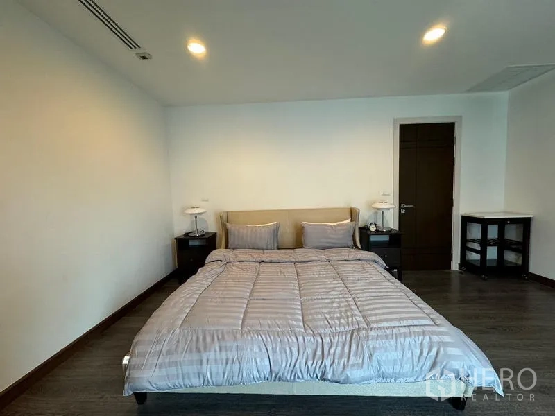 Condominium for rent in Pathum Wan, Bangkok - Spacious master bedroom with king bed, recessed lighting, and dark wood floors.