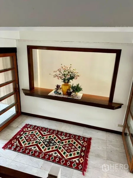Home Office for rent in Khlong Toei, Bangkok - Compact bathroom vanity with arched mirror, granite counter and pink tiles.