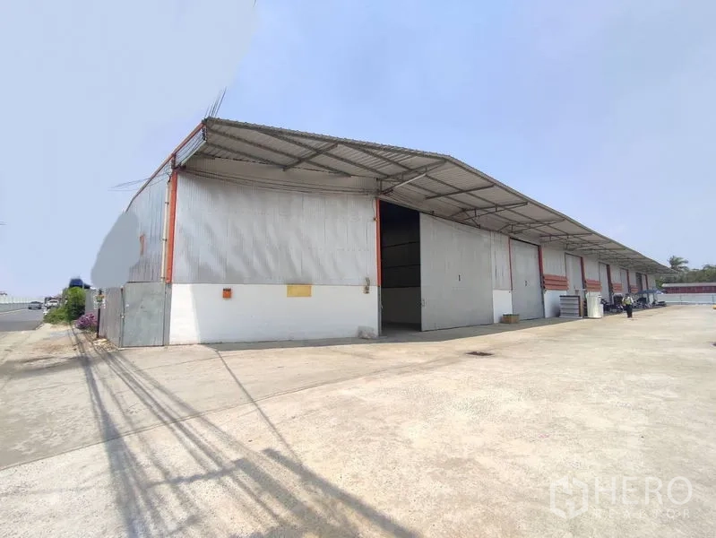 Warehouse for rent in Pathum Thani - Corner view of the warehouse row with open bay, steel canopy and truck-friendly driveway.