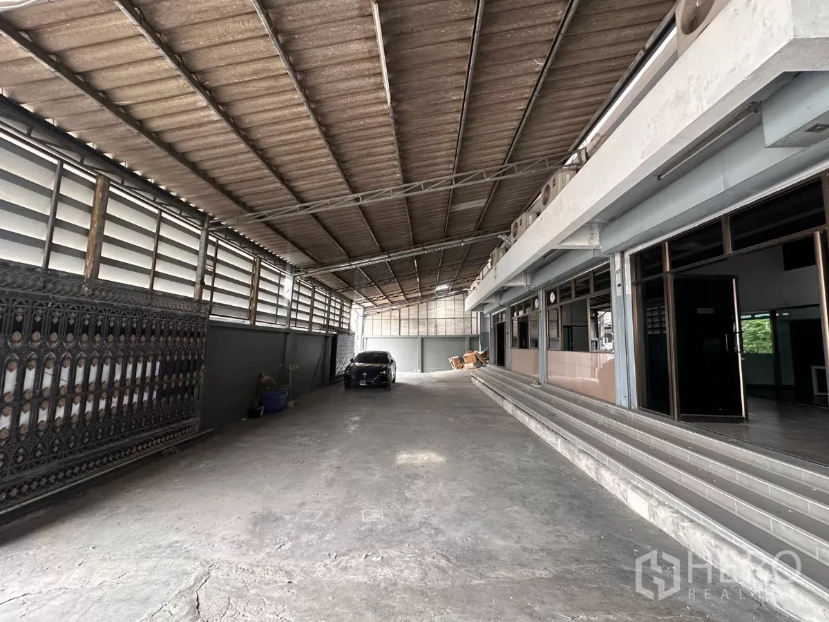Factory for rent in Bang Phli, Samut Prakan - Covered loading corridor with driveway and glass offices along one side.
