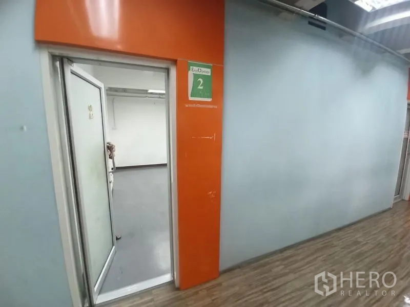 Office Space for rent in Ratchathewi, Bangkok - Hallway view toward the open doorway of office suite number 2 with orange cladding.