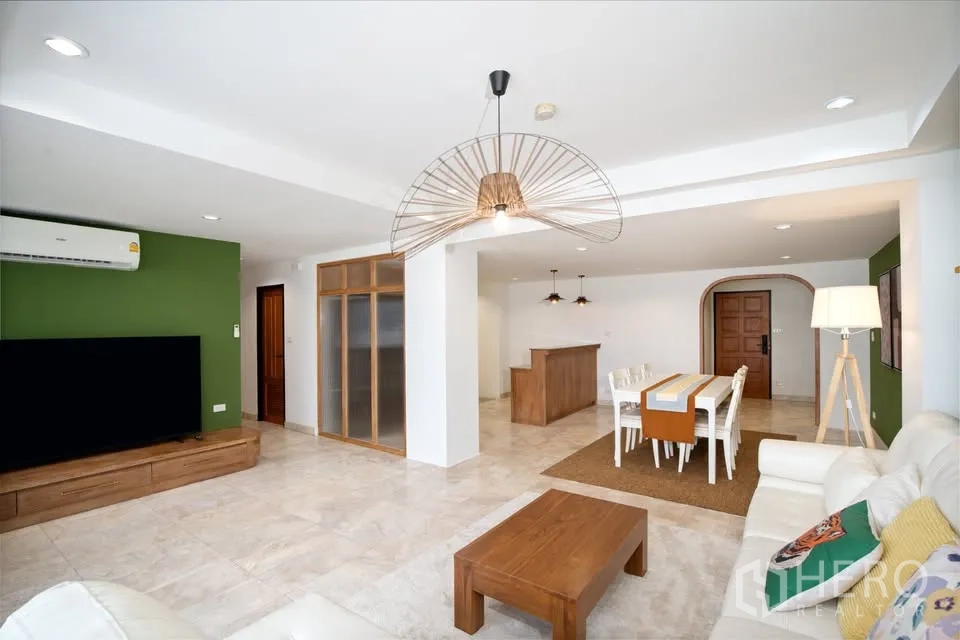 คอนโด for rent in Watthana, Bangkok - พื้นที่นั่งเล่นและรับประทานอาหารแบบเปิด โซฟาสีขาว ทีวี และโคมไฟแขวน