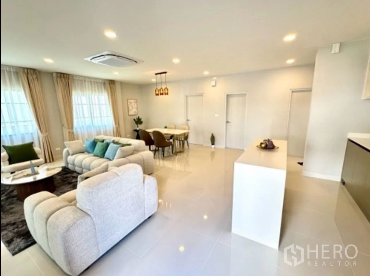 Detached House for rent in Bang Phli, Samut Prakan - Bright open-plan living and dining room with sofas, table and central island.