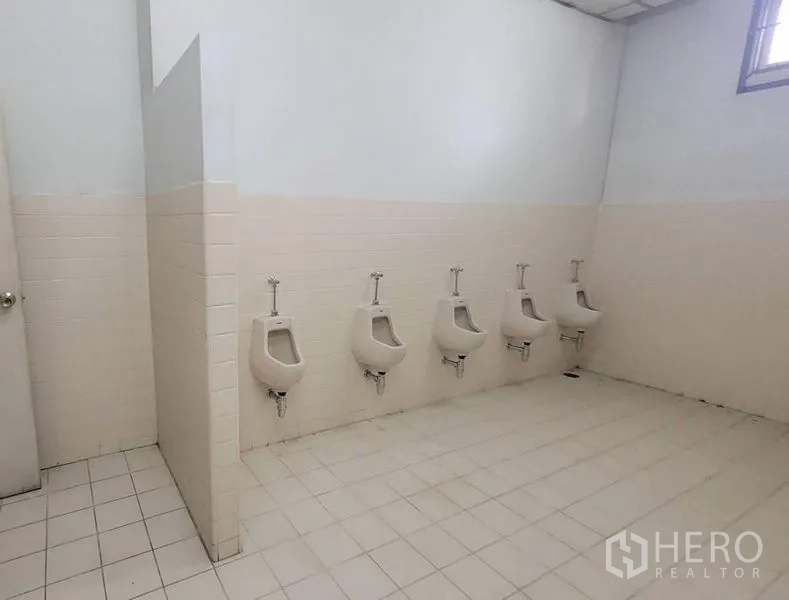 Factory for rent in Mueang Samut Prakan, Samut Prakan - Clean male restroom with tiled floor and a row of urinals