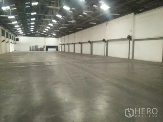 Warehouse for rent in Khlong Luang, Pathum Thani - Spacious warehouse interior with high steel roof, polished concrete floor and wall fans.