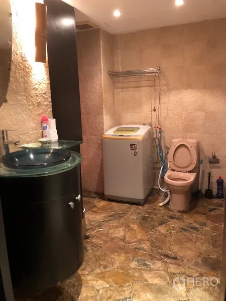 公寓 出租在Watthana, Bangkok - 浴室配玻璃面盆、坐便器与室内洗衣机。