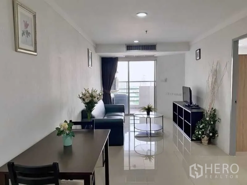 公寓 出租在Khlong Toei, Bangkok - 明亮客厅，配沙发、电视柜、餐桌并连通阳台的素坤逸公寓。
