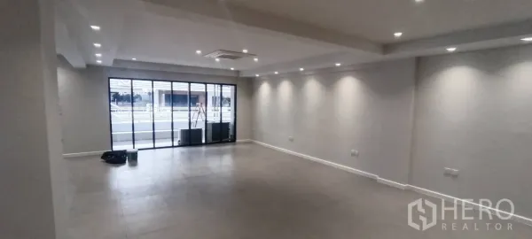 Office Space for rent in Watthana, Bangkok - Open-plan office with sliding glass doors, recessed lighting, and tiled floors.