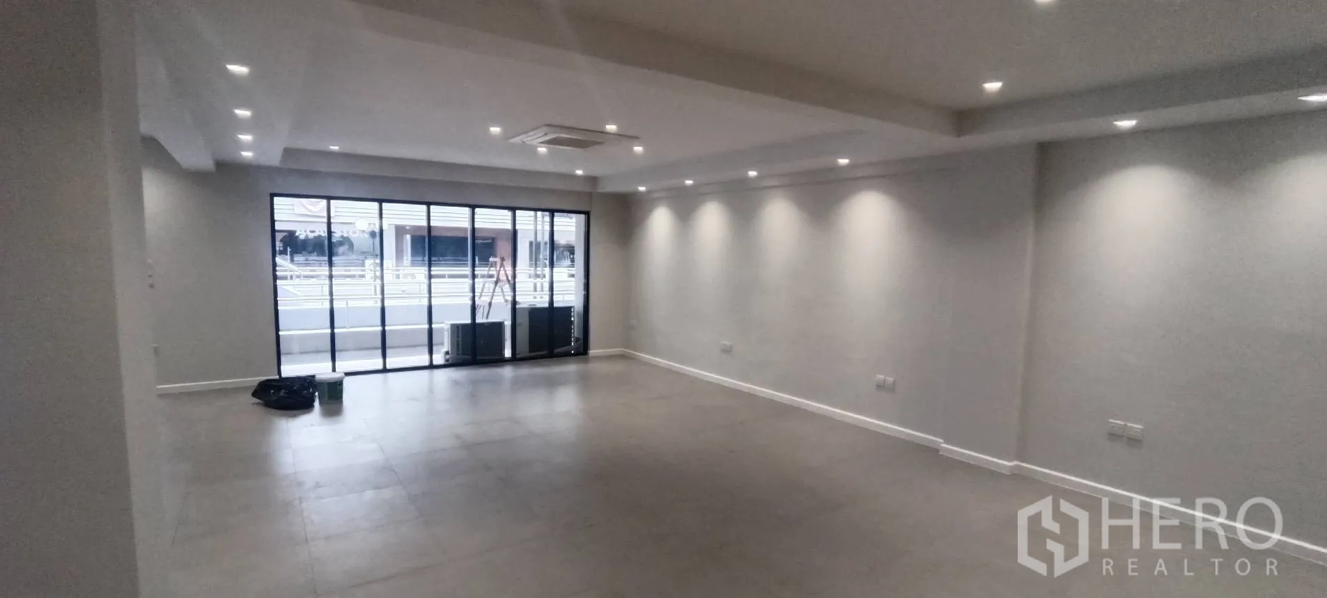 Office Space for rent in Watthana, Bangkok - Open-plan office with sliding glass doors, recessed lighting, and tiled floors.