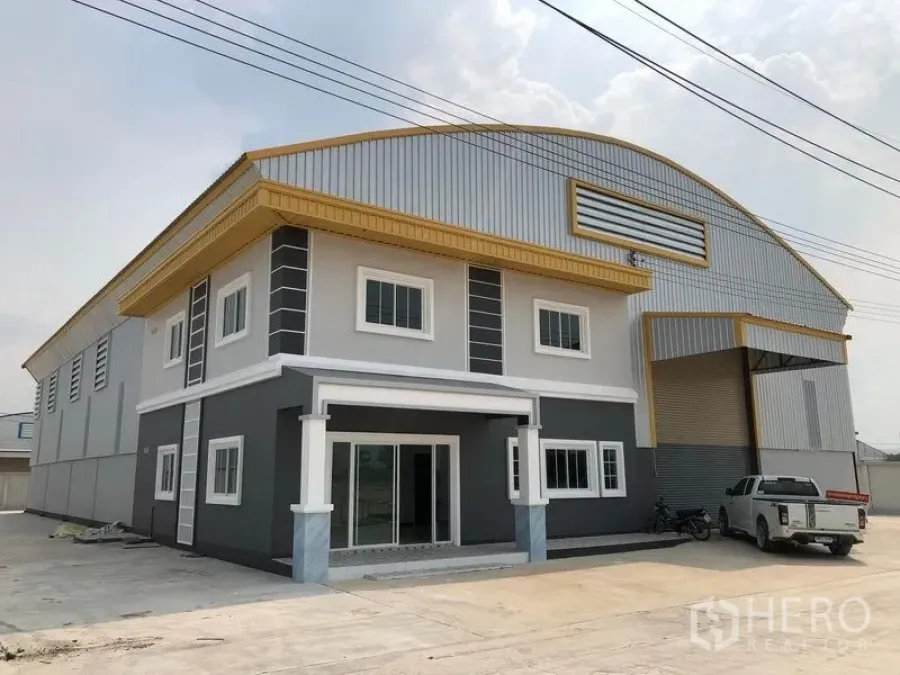 โรงงาน ให้เช่าหรือขายในBang Len, Nakhon Pathom - ด้านหน้าอาคารโรงงานสมัยใหม่พร้อมออฟฟิศ 2 ชั้นและประตูโรลเลอร์ขนาดใหญ่