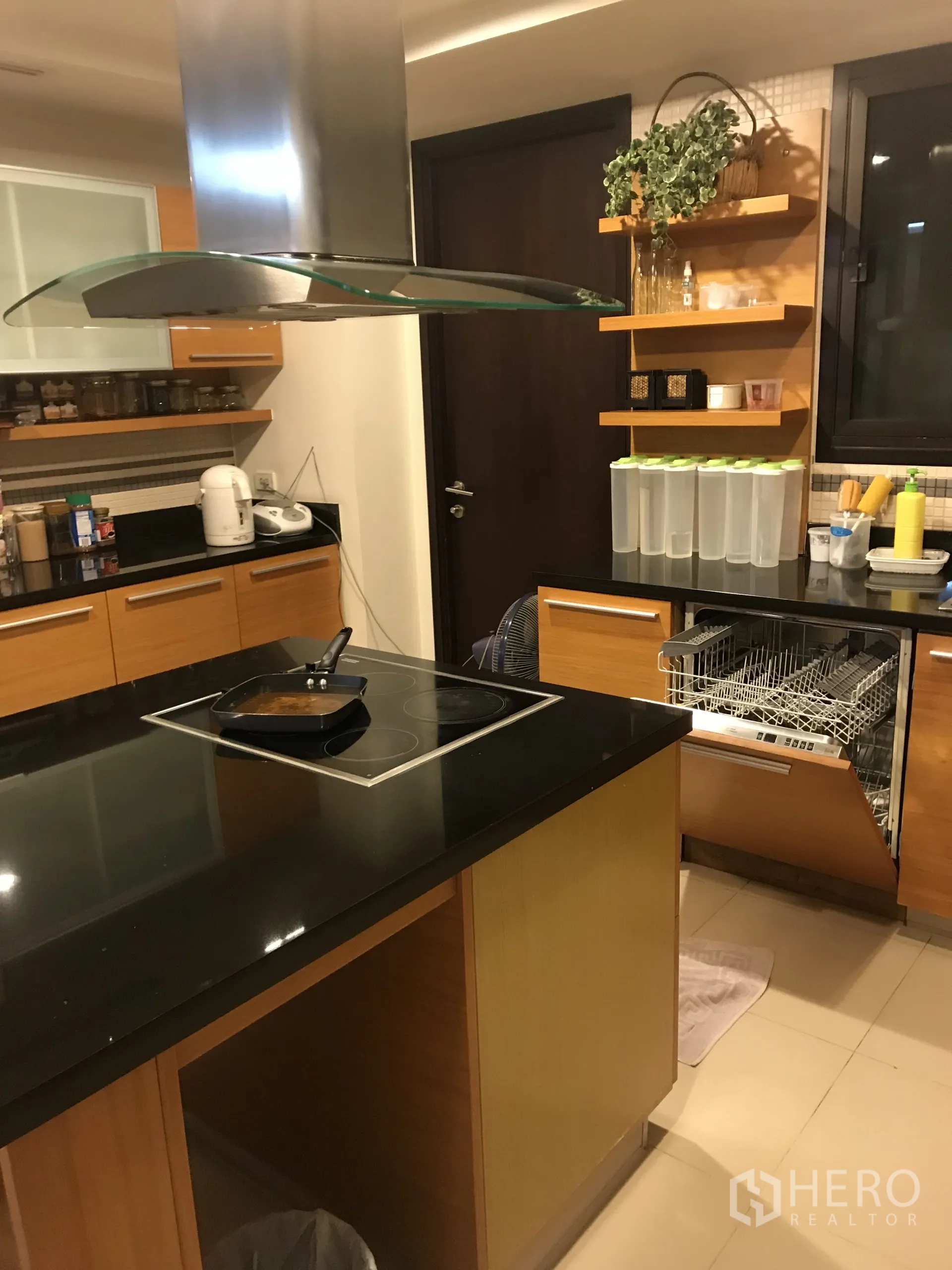 公寓 出售在Yan Nawa, Bangkok - 现代厨房设中岛电陶炉、不锈钢烟机、黑色石材台面和洗碗机。