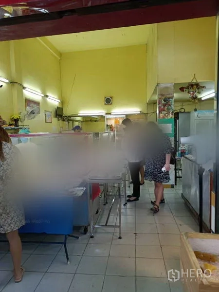 店屋 出租在Phaya Thai, Bangkok - 店屋底层室内，高挑天花与黄色墙面，瓷砖地面与不锈钢操作台，适合餐饮或零售布局