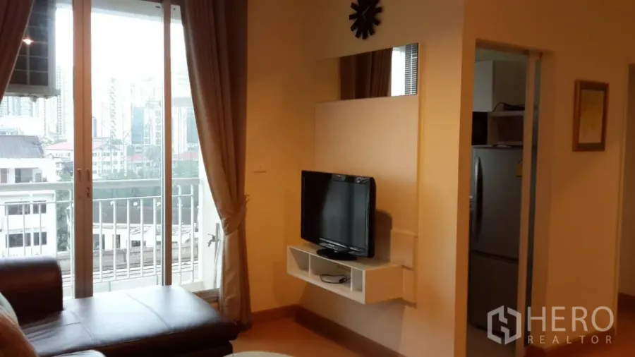 คอนโด ให้เช่าในWatthana, Bangkok - ห้องนั่งเล่นสว่างพร้อมประตูกระจกบานเลื่อนออกสู่ระเบียง วิวเมือง และชั้นวางทีวี