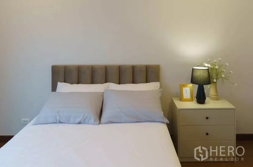 独立式住宅 出租或出售在Bang Phli, Samut Prakan - 简约卧室，床、床头柜与台灯。