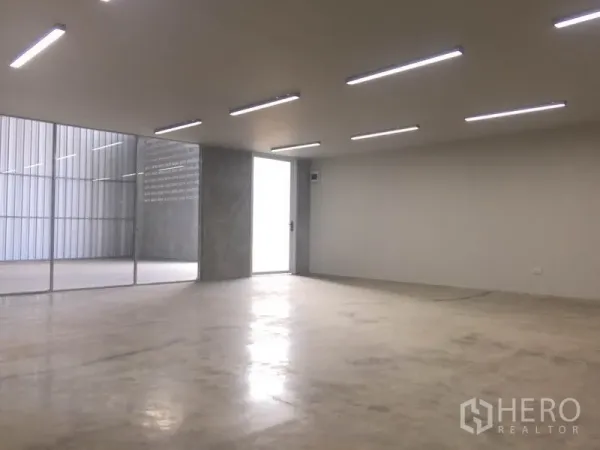 Factory for rent in Mueang Samut Prakan, Samut Prakan - Open-plan office space with LED lighting and glass partition beside the warehouse.