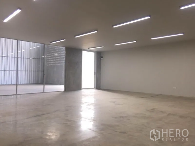 Factory for rent in Mueang Samut Prakan, Samut Prakan - Open-plan office space with LED lighting and glass partition beside the warehouse.