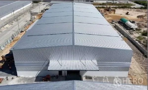 货栈 出租在Mueang Rayong, Rayong - 工业区内的大型现代化仓库航拍图，金属屋顶，装卸雨棚与硬化场地。