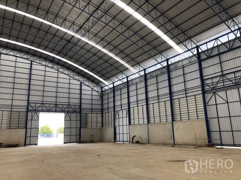 Factory for rent or sale in Lat Lum Kaeo, Pathum Thani - Corner of the high-bay interior with ventilated wall panels and oversized doorway.