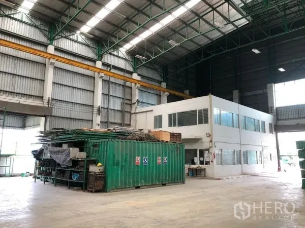 Factory for rent or sale in Lat Lum Kaeo, Pathum Thani - Wide production hall with green container storage and a mezzanine‑height office block.