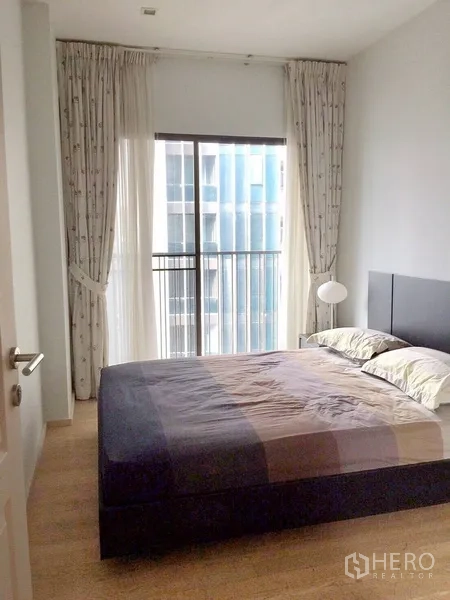 公寓 出租在Bangkok - 卧室配大床，落地窗与推拉门，可通向窄阳台。
