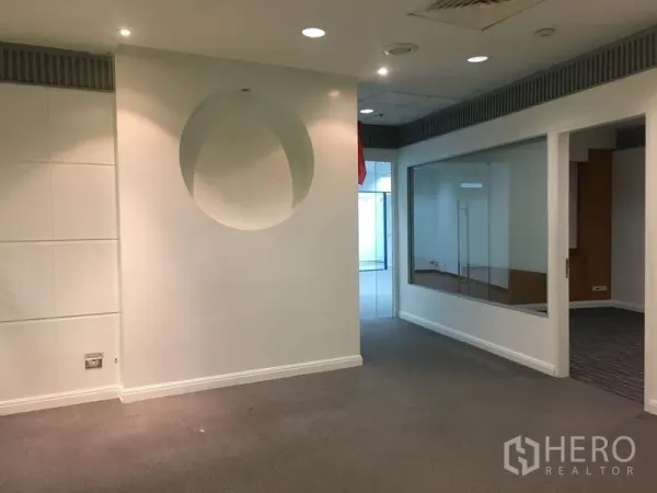 Office Space for rent in Chatuchak, Bangkok - Reception area with circular wall niche, carpet flooring, and a glass-partitioned meeting room.