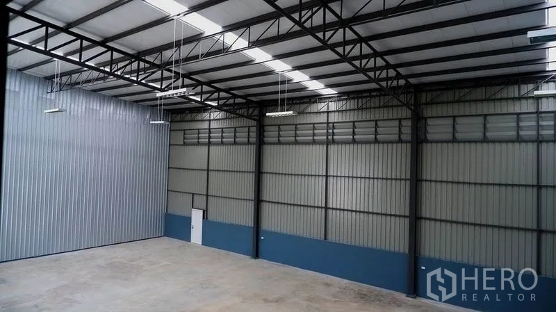 Warehouse for rent in Bueng Kum, Bangkok - High-clearance warehouse interior with steel trusses, insulated roof panels and bright LED lighting.
