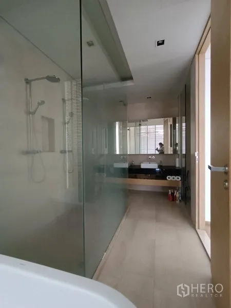 Condominium for rent or sale in Bang Rak, Bangkok - Master bathroom with glass-enclosed shower, soaking tub and double vanity.