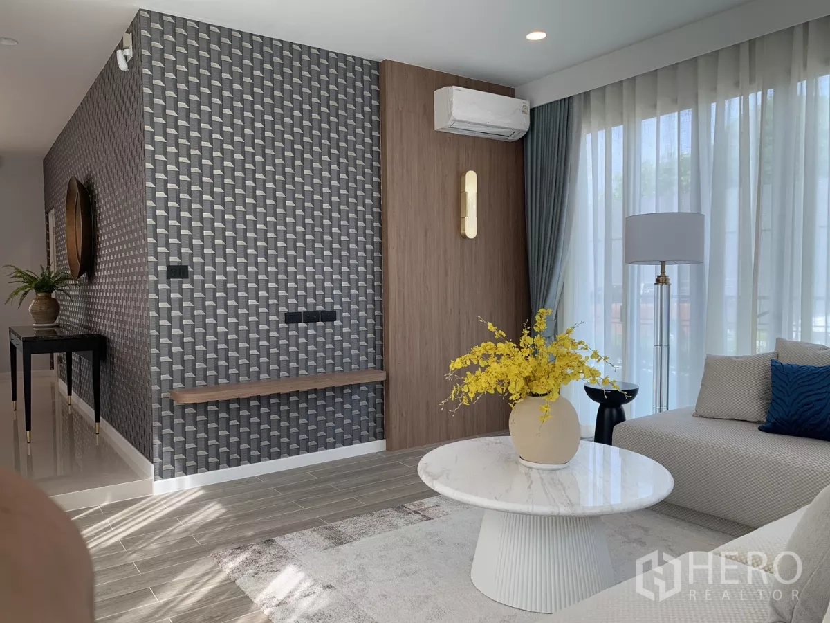Detached House for rent in Bang Kapi, Bangkok - Contemporary lounge with geometric accent wall, air conditioner and marble coffee table in Bang Kapi home.