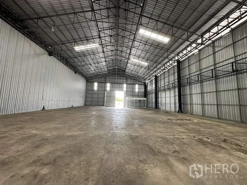 货栈 出租在Pak Kret, Nonthaburi - 仓库内部纵深视角，高钢架屋顶面向主出入口。
