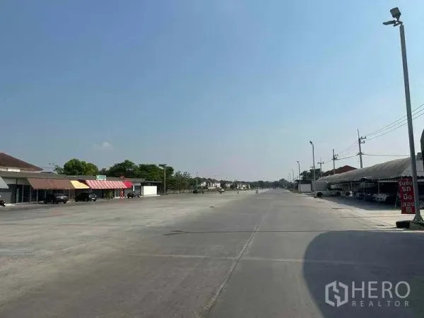 Retail Space for rent in Pathum Thani - Long internal roadway through the commercial complex with streetlights and shops on the left.
