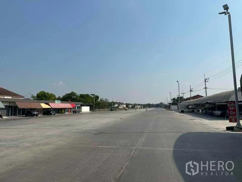 Retail Space for rent in Pathum Thani - Long internal roadway through the commercial complex with streetlights and shops on the left.