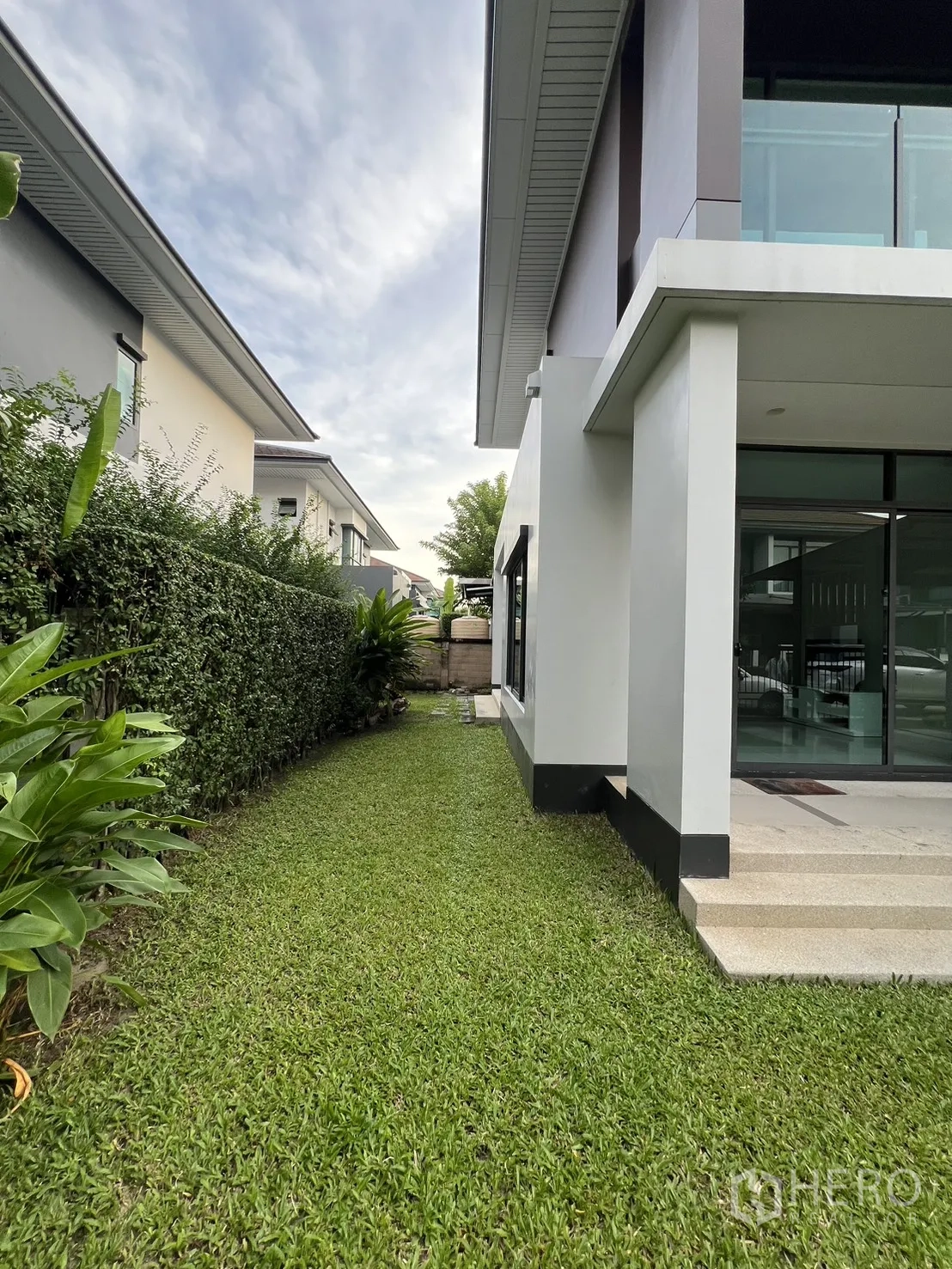 Detached House for rent in Bang Kapi, Bangkok - Long side lawn bordered by a hedge next to the house.