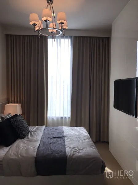 公寓 出租或出售在Watthana, Bangkok - 卧室内落地窗配双层窗帘与壁挂电视，顶上吊灯