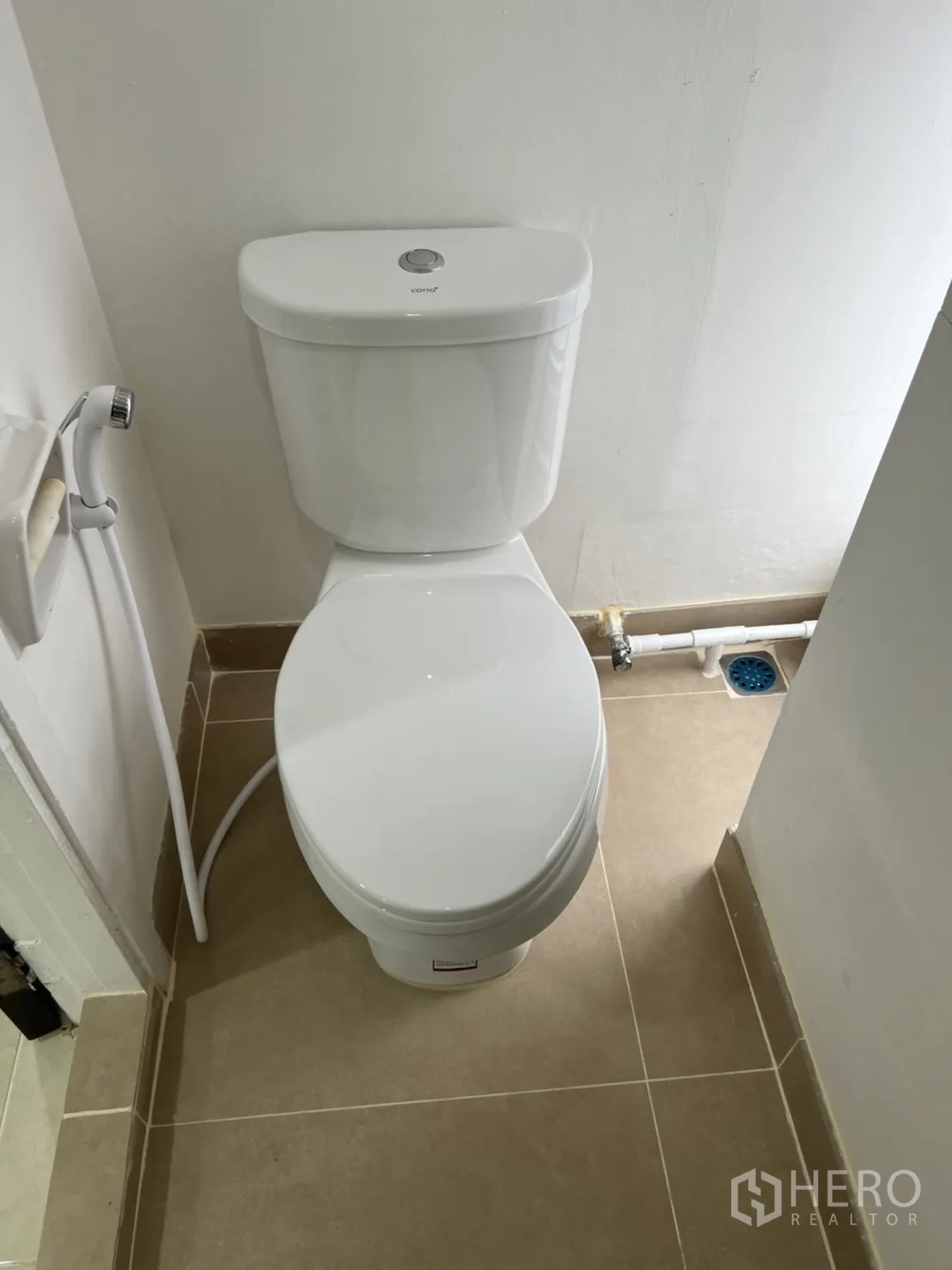 Shophouse for rent in Watthana, Bangkok - Clean toilet room with handheld bidet on a beige tiled floor.