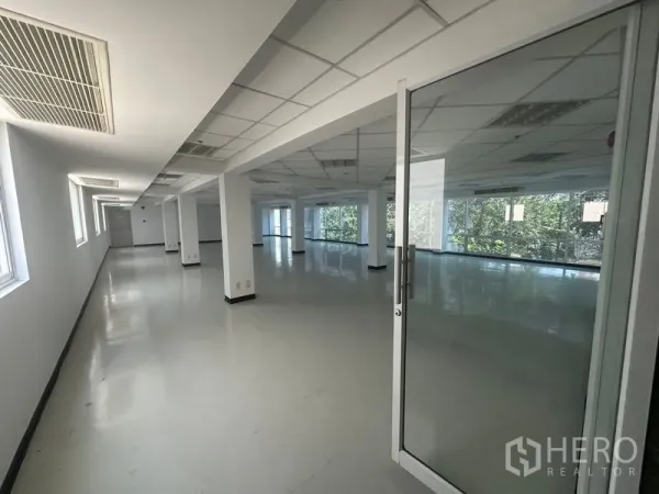 办公空间 出租在Phaya Thai, Bangkok - 开放式办公楼层，玻璃门入口、网格吊顶、空调出风口与侧窗，引入充足自然光。
