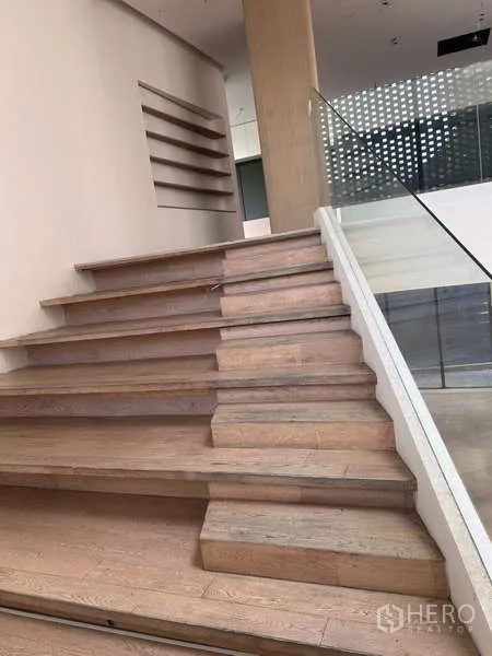 Standalone for rent in Khlong Toei, Bangkok - Upper landing with glass railing and perforated screen window for filtered daylight.