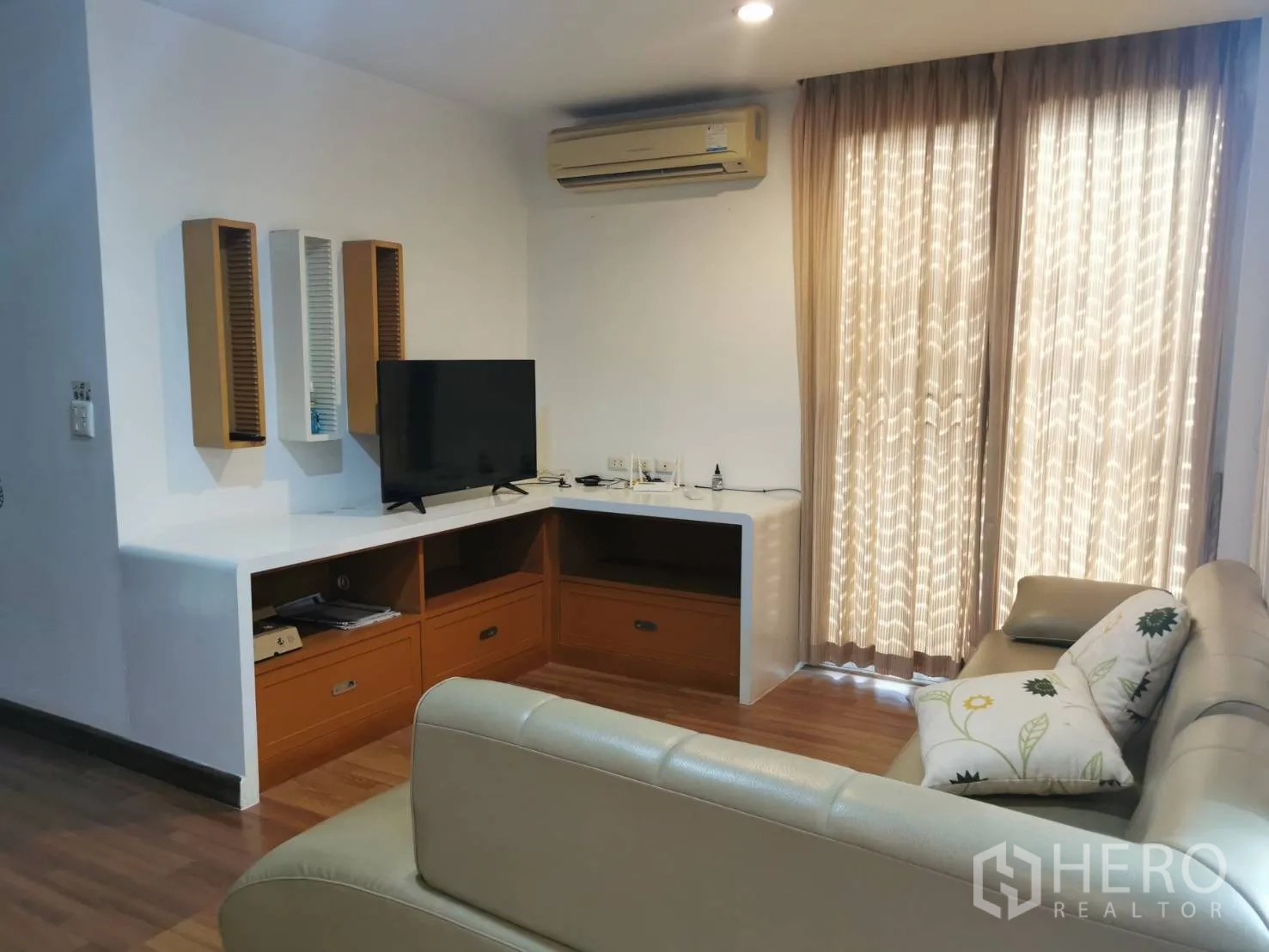 Townhouse for rent or sale in Yan Nawa, Bangkok - Upstairs family room with sofa, TV console, air conditioning and sheer curtains.