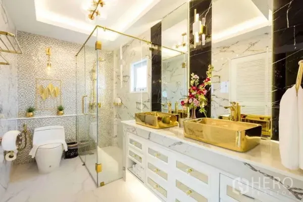 Townhouse for rent in Lat Phrao, Bangkok - Luxurious marble bathroom with gold fixtures, double vanity and glass-enclosed shower.