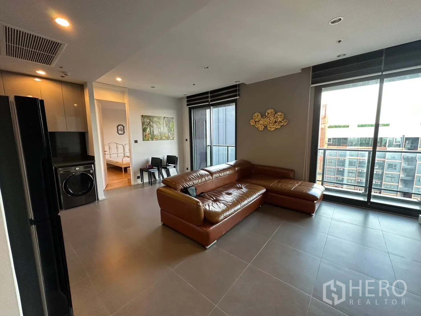 Condominium for rent or sale in Chatuchak, Bangkok - Living area facing balcony and sliding glass doors beside the kitchen.