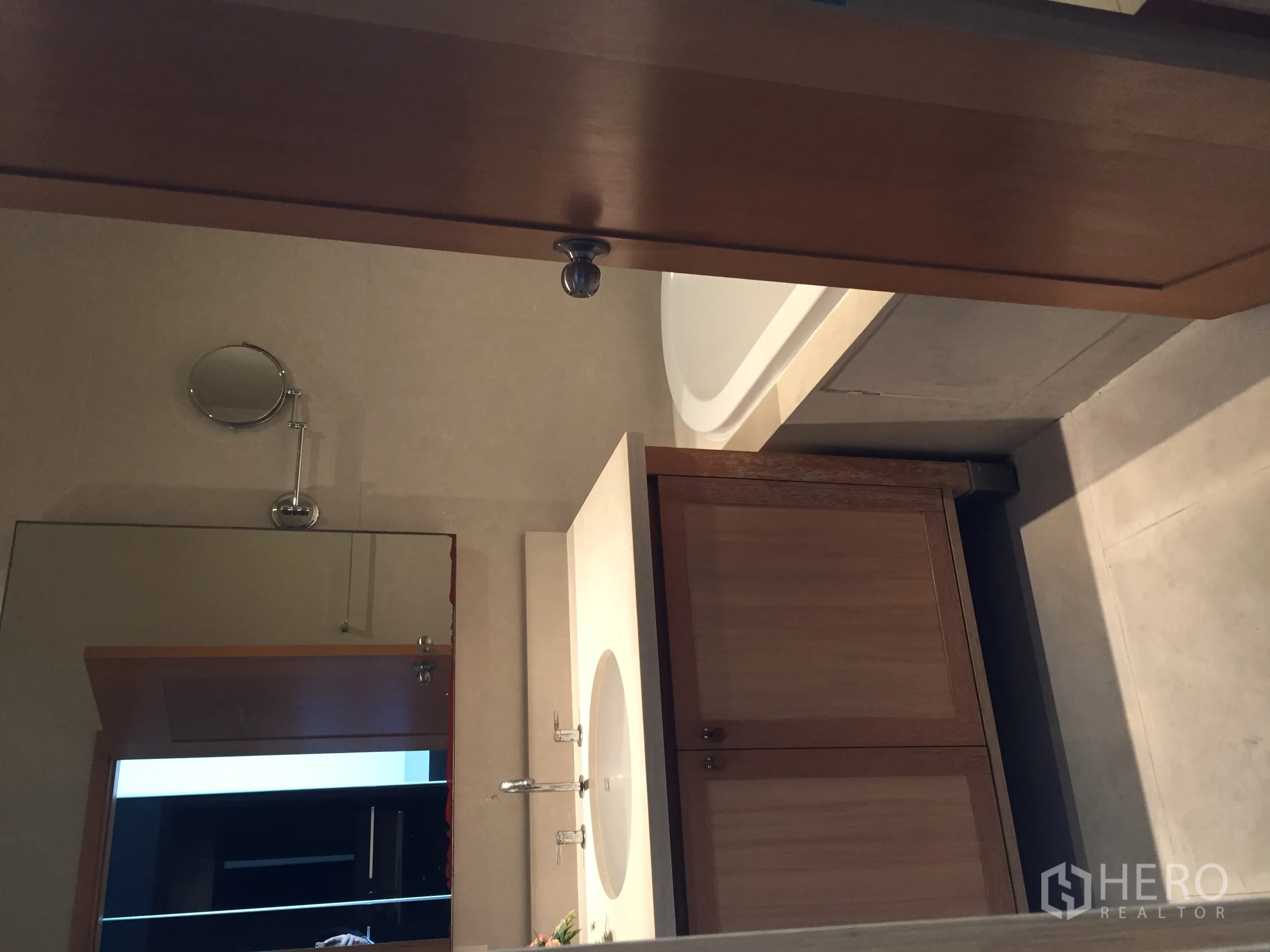 Condominium for rent in Khlong Toei, Bangkok - Contemporary bathroom with bathtub, large mirror and wood vanity cabinet.